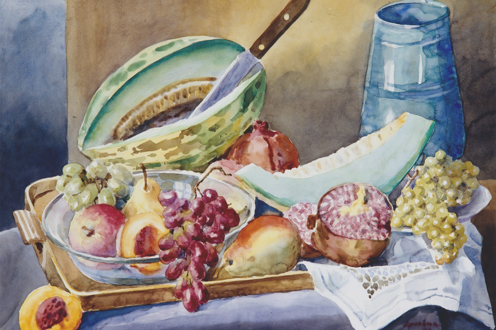 Stilleben mit Obst, darunter Melone, Trauben, Granatapfel und Birne, sowie einem blauen Krug und einer Schüssel auf einem Tisch.